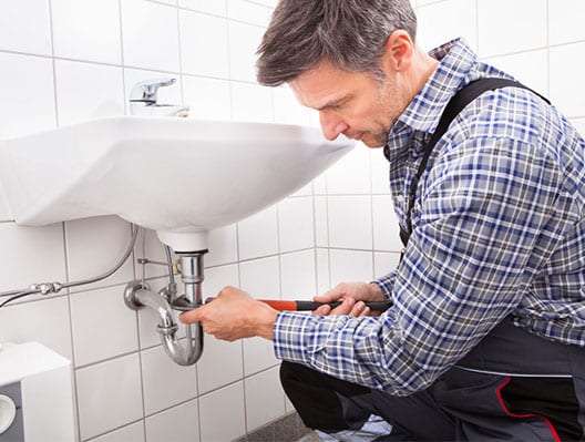 Maintenance worker fixing sink