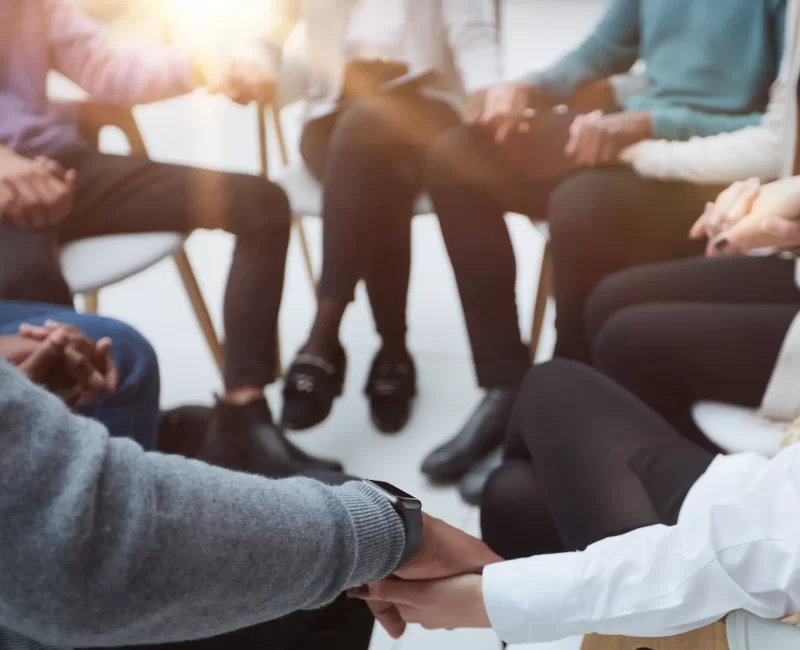 closeup-business-team-sitting-holding-hands closeup-business-team-sitting-holding-hands