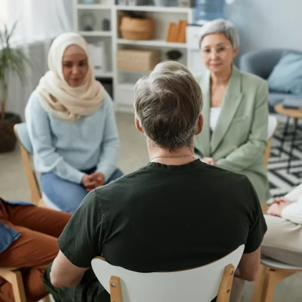 focus-rear-view-mature-male-patient-counselor-sitting-front-group focus-rear-view-mature-male-patient-counselor-sitting-front-group
